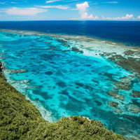 三角点からの宮古島・伊良部方面を空撮した断崖絶壁の海岸線の写真
