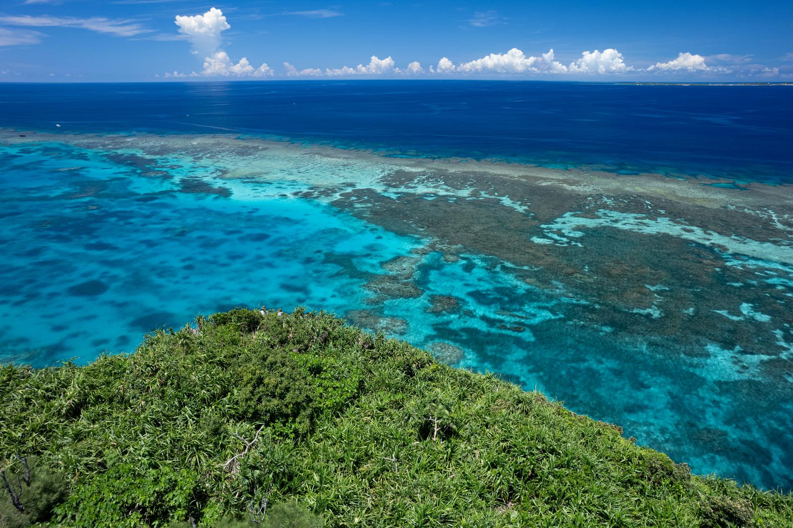 宮古島の三角点から見た珊瑚礁と紺碧の海の空撮