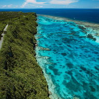 宮古島の三角点から見る伊良部の断崖海岸とターコイズブルーの海の写真