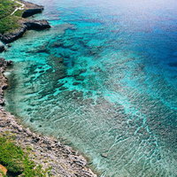 宮古島の岬から見た透明度の高いエメラルドグリーンの海の写真