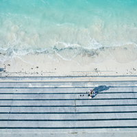 宮古島の透明な海で話し込む3人組の夏休みの写真