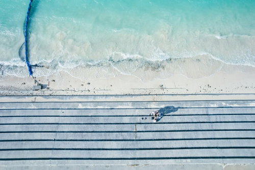 宮古島の透明な海で話し込む3人組の夏休み