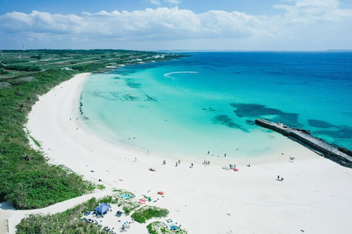宮古島の海水浴場に集う海水浴客と白い砂浜の風景
