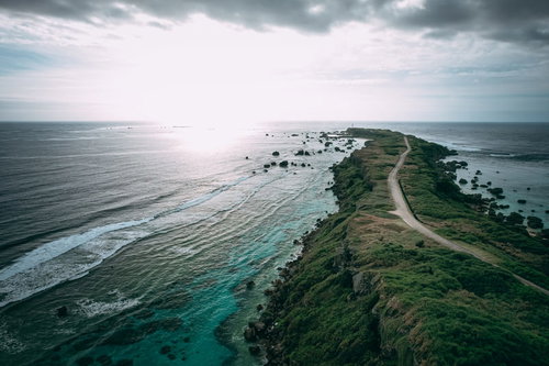 平安名埼灯台に続く一本道と透明な海（空撮）