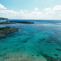 透明度抜群の宮古島の海と防波堤、白い砂底と岩礁が透ける風景の写真
