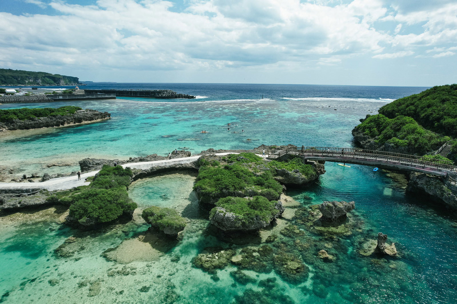 宮古島の遊歩道と透明な岩礁の海岸、ターコイズブルーの遠浅の海の写真