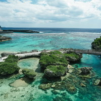 宮古島の遊歩道と透明な岩礁の海岸、ターコイズブルーの遠浅の海の写真