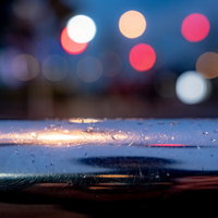 手すりの雨粒と玉ボケの夜景・夜間街灯のライト表現の写真
