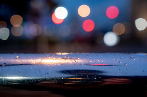 手すりの雨粒と玉ボケの夜景・夜間街灯のライト表現