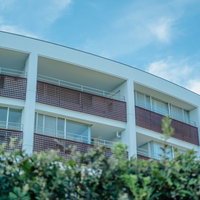 逗子マリーナ周辺の白い建物と街並み、青空と緑の現代建築の写真