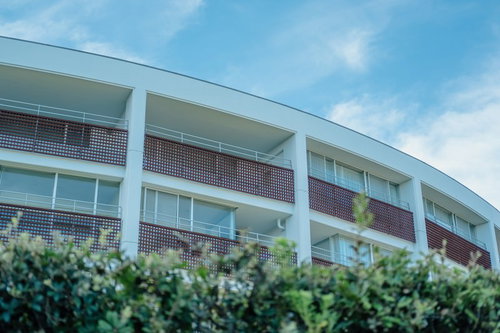 逗子マリーナ周辺の白い建物と街並み、青空と緑の現代建築