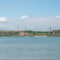 屛風ヶ浦の海食崖と風力発電が見える海岸風景の写真