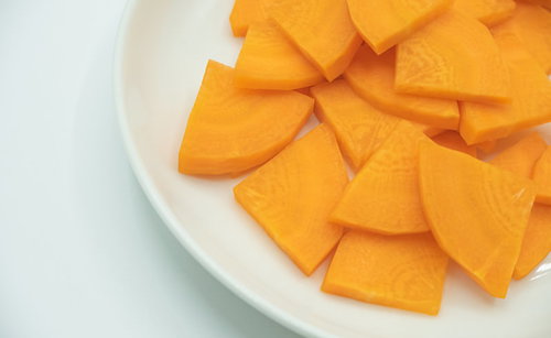 白い皿に盛られたいちょう切りにされた人参