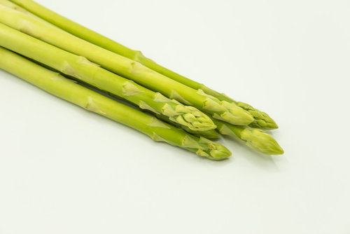 白い背景に並べた新鮮なアスパラガス5本の野菜