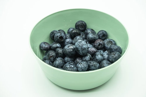 緑色のボウルに盛られた摘みたてブルーベリー