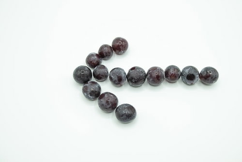 濃い紫色の巨峰の粒を並べた左向き矢印のデザイン