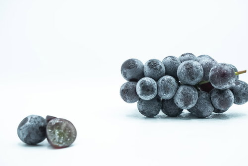 種なし巨峰の房と粒、表面に光る水滴と新鮮な葡萄の