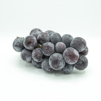 白い背景に置いた種なし巨峰の房、水滴付きの新鮮な葡萄の写真