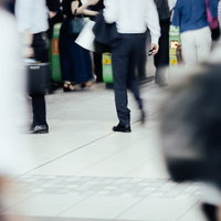 人の往来が多い駅の改札を行き交う人々の群衆の写真