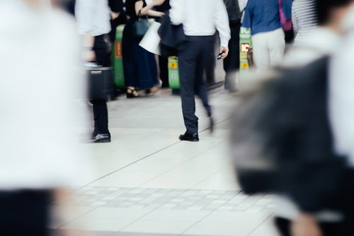 人の往来が多い駅の改札を行き交う人々の群衆