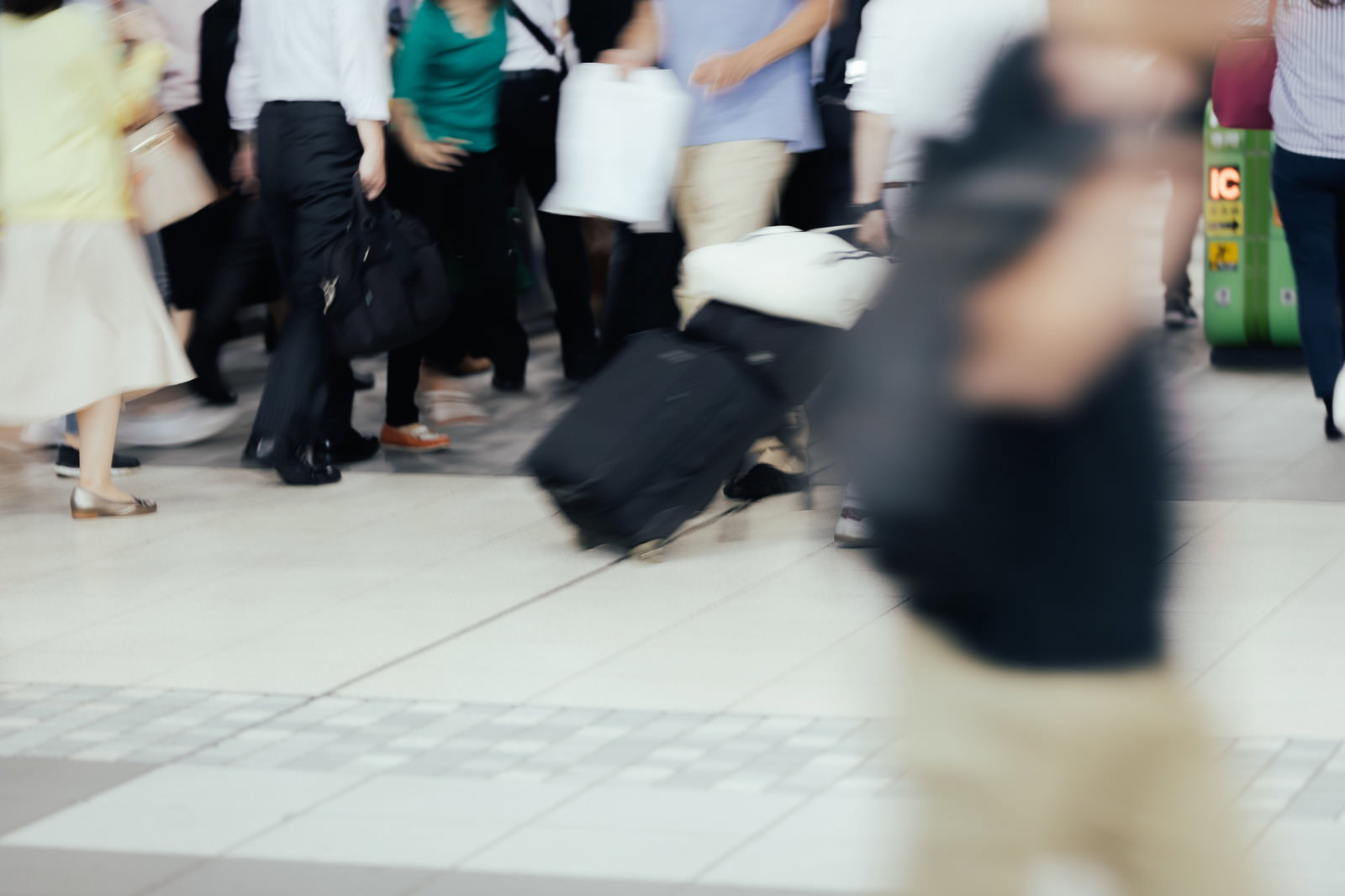 改札を通る多くの人々がブレて写っている駅の風景