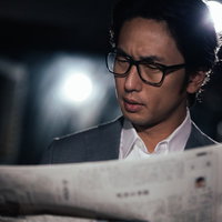 事件を紙面で知る刑事の男性が新聞を読む姿の写真