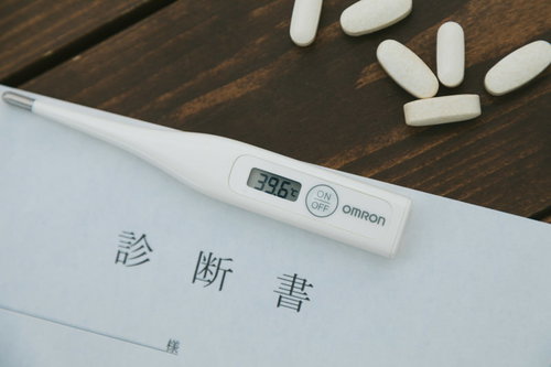 処方してもらった錠剤と診断書、体温計で示す高熱と医療対応