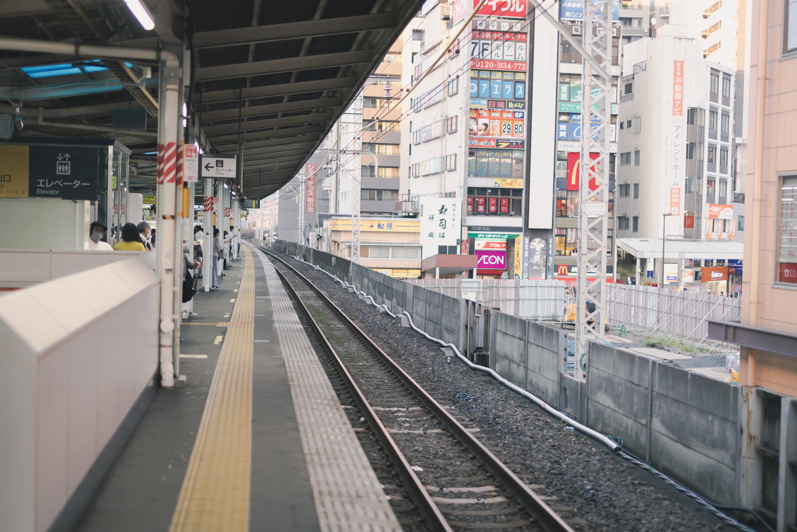 新小岩駅のホームと線路、背景に高層ビルが見える風景