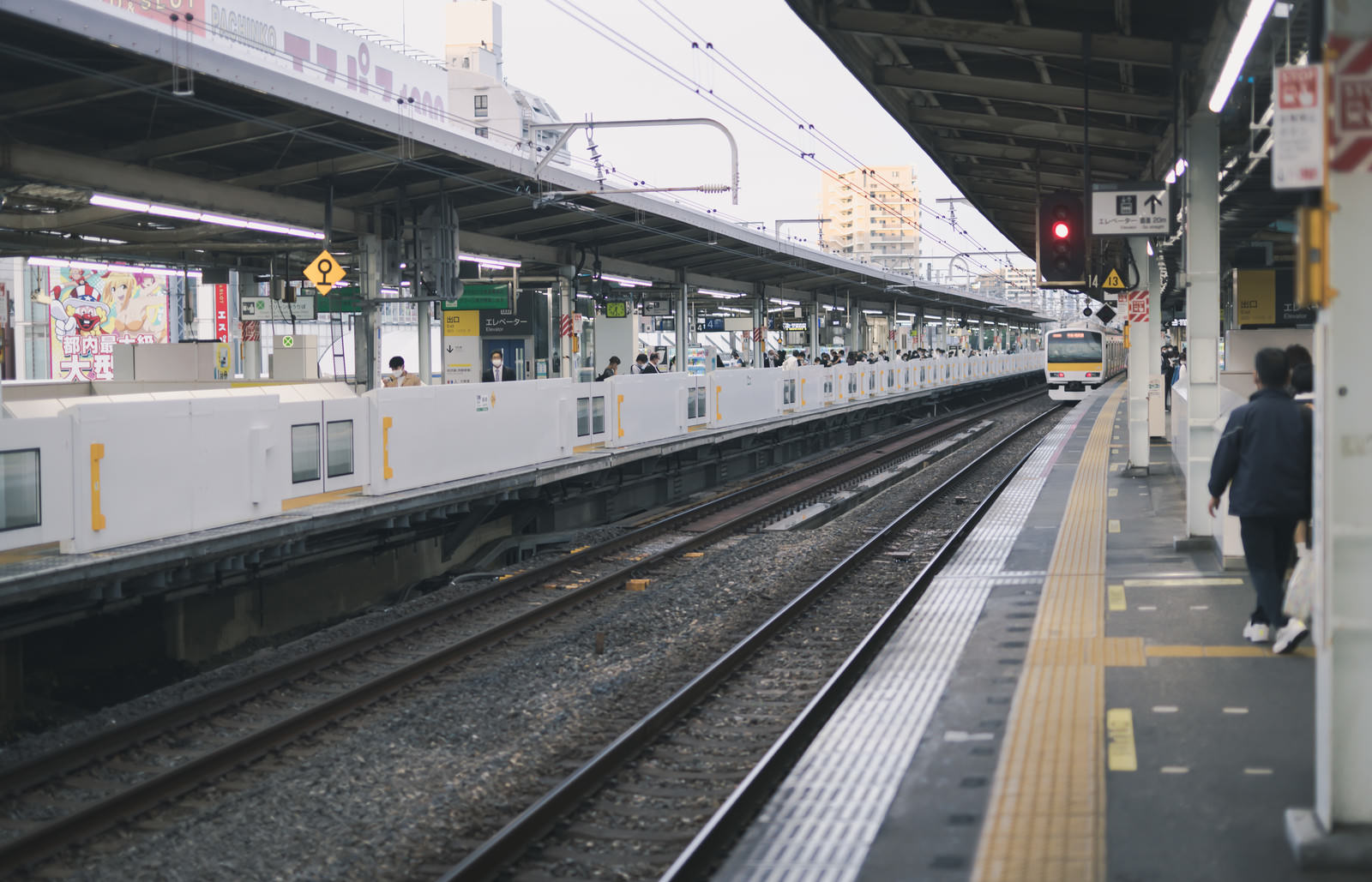 片側にホームドアが設置された新小岩駅のホームに電車が停車している