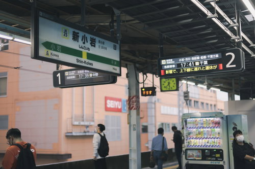 総武線の新小岩駅ホームに停車するオレンジ色の電車