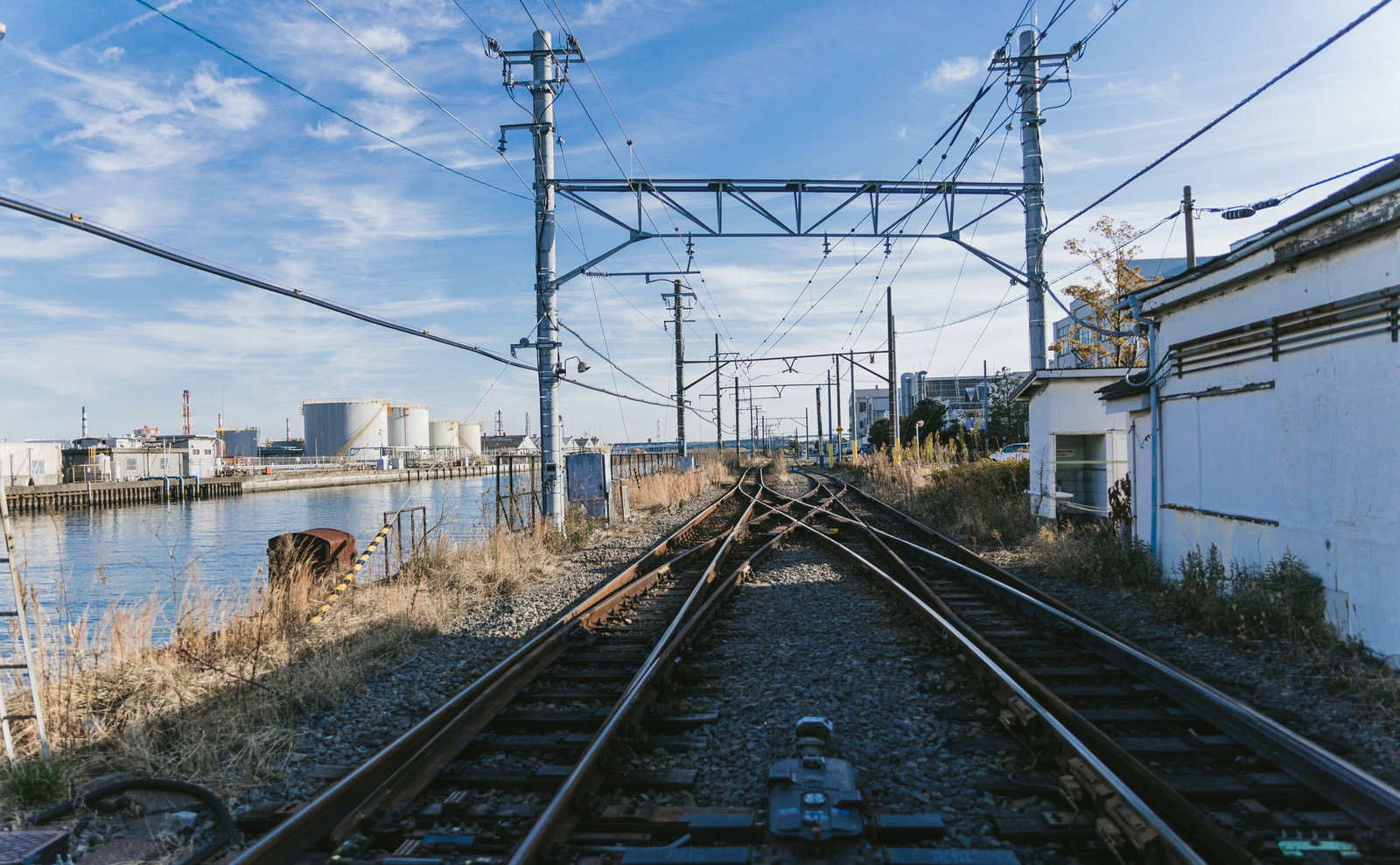 新芝浦駅の線路が奥へ伸び架線柱が並ぶ風景