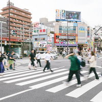 新大久保駅前の交差点を往来する人たちと横断歩道の写真