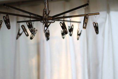 物干し竿に連なる茶色い洗濯バサミの部屋干し風景