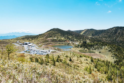 草津白根山の弓池と観光地の駐車場周辺の高原風景