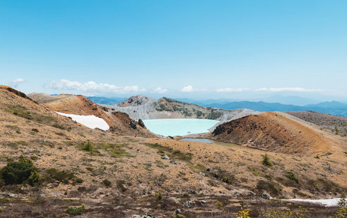 草津白根山の山頂付近にある乳白色の湯釜と火山湖の絶景