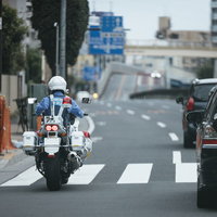 公道を走行中の白バイと警察官による交通取締パトロールの写真