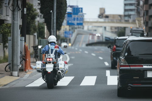 公道を走行中の白バイと警察官による交通取締パトロール