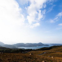 川内峠の草原から望む海と山並みの写真
