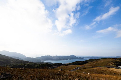 川内峠の草原から望む海と山並みの写真