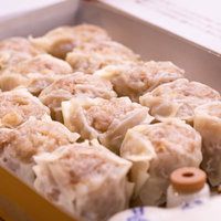 蒸篭に並んだ美味しそうなシウマイ、竹製せいろの点心の写真