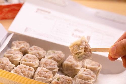 大好物の一口焼売（シウマイ）を箸でつまむ