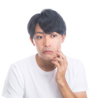 顔のハリ具合を気にして頬を触る男性のスキンケアの写真