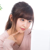 鏡を見ながら肌の状態を確認するスキンケアケアをする若い女性の写真