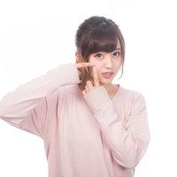 指でニキビを潰したくなる困った表情の女性の写真