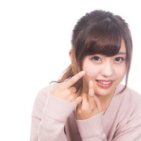 頬のニキビが気になる若い女性の肌悩みとスキンケアの写真