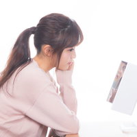 洗面台の鏡の前でスキンケアをする美肌にうっとり女子の写真