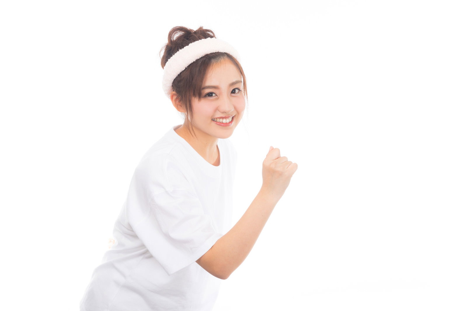 白い服を着た女性が笑顔でガッツポーズをしている様子［モデル：河村友歌］