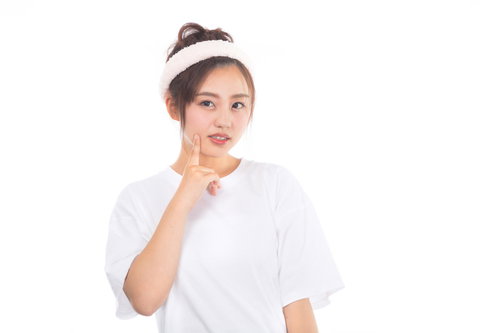 頬の吹き出物が気になるスキンケア中の女性