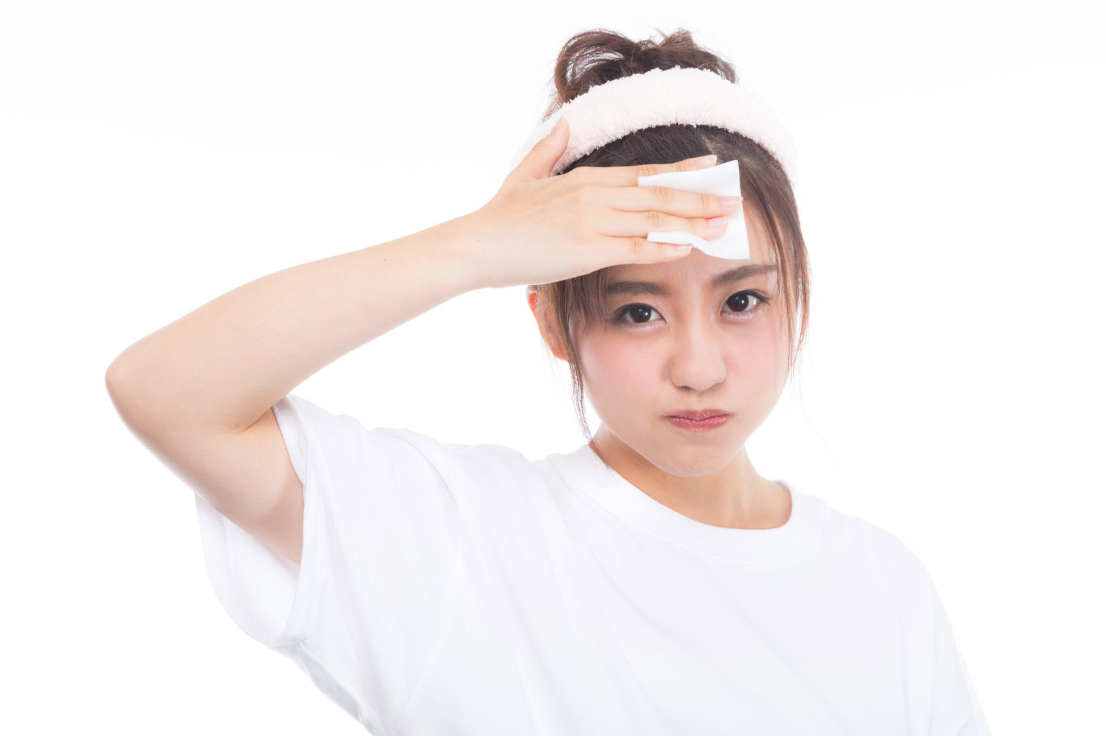 コットンを使って額のメイクを落としている白いトップスの女性［モデル：河村友歌］