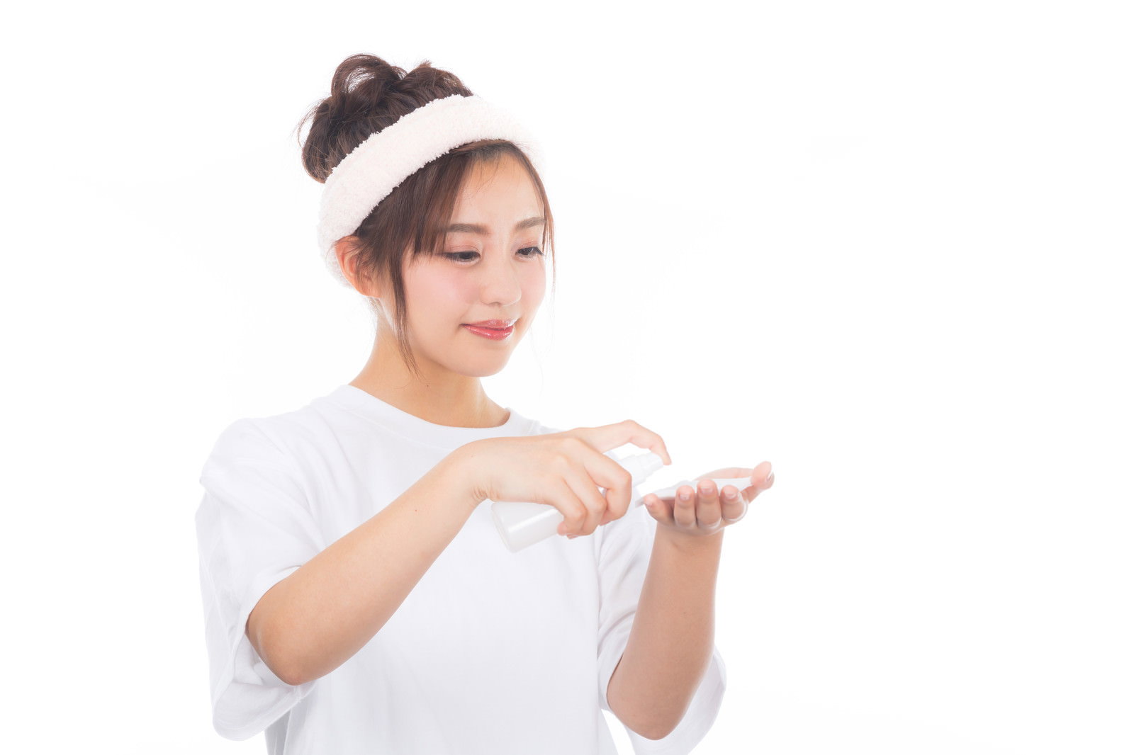 白いヘアバンドをした女性がコットンに化粧水をつけている様子［モデル：河村友歌］